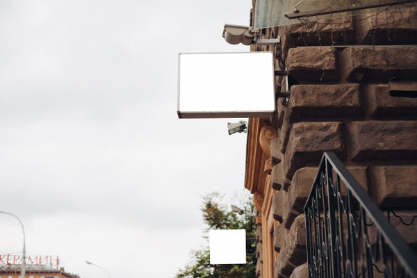 Free A Billboard, Mockup, From The Side Of An Building Outside Against A Beautiful Blue Sky Psd