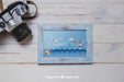 Free Camera And Frame On Wooden Planks Psd