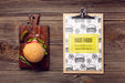Free Clipboard And Burger On Wooden Background Psd