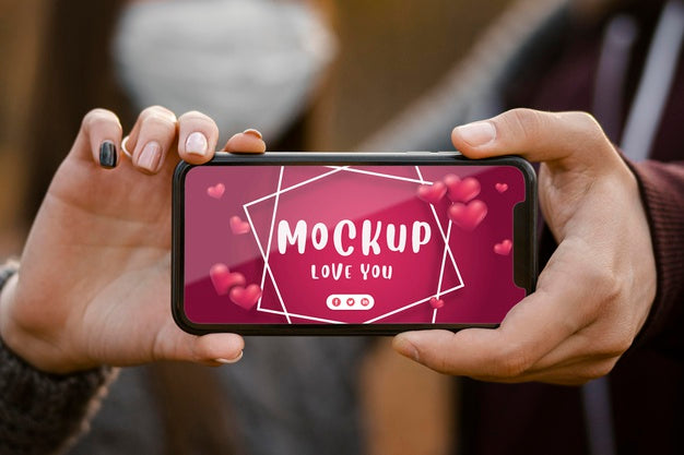 Free Close-Up Couple With Mask Holding Phone Psd