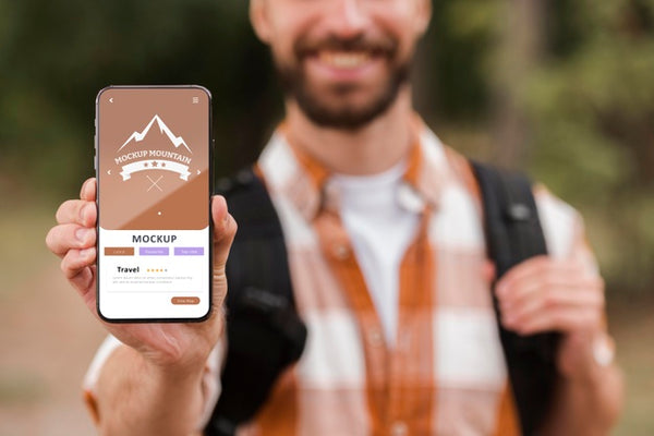 Free Front View Of Smiley Man Holding Smartphone While Camping Psd