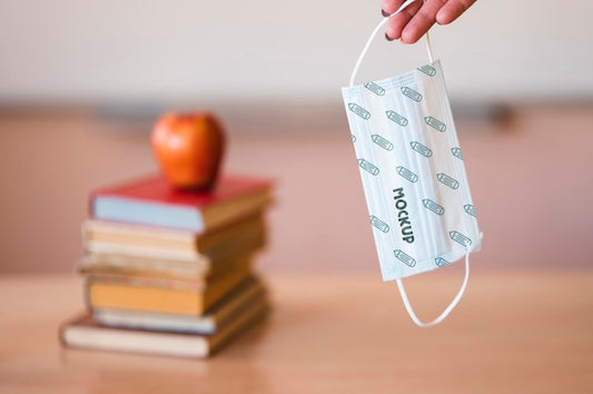Free Front View Of Teacher Holding Medical Mask With Books And Apple Psd