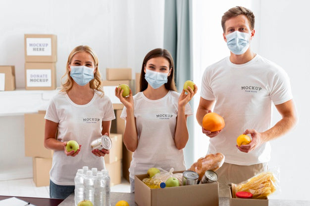 Free Front View Of Volunteers With Medical Masks Preparing Food Donations Psd