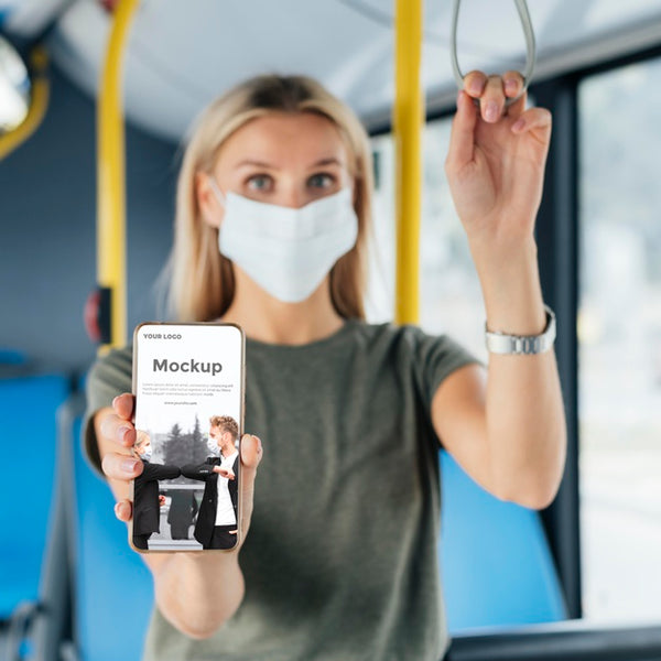 Free Front View Of Woman With Medical Mask In The Bus Holding Up Smartphone Psd