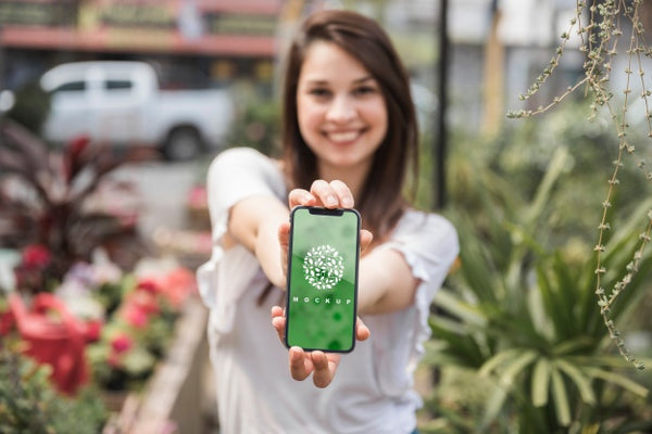 Free Girl Holding Smartphone Mockup With Gardening Concept Psd