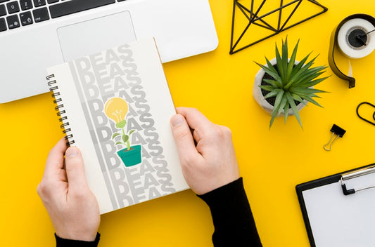 Free Hands Holding Notebook Mock-Up Over Desk Psd