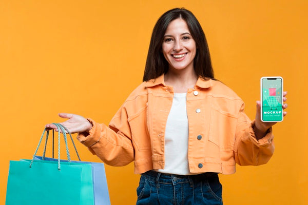 Free Happy Woman Holding Shopping Bags And A Phone Mock-Up Psd