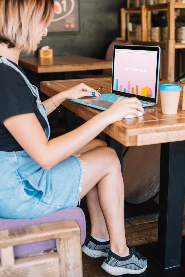 Free Laptop Mockup With Woman On Wooden Table Psd