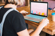 Free Laptop Mockup With Woman On Wooden Table Psd