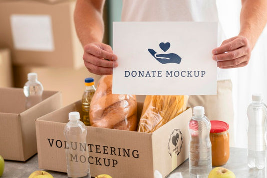 Free Male Volunteer Holding Blank Paper With Box Of Food For Donation Psd