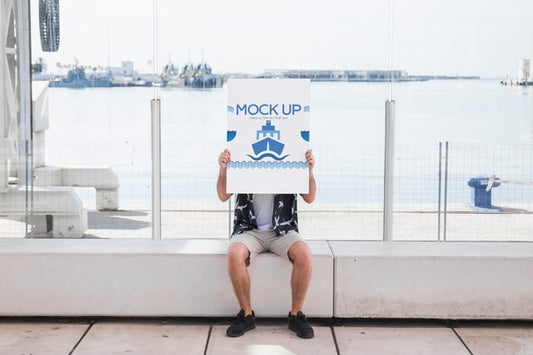 Free Man Holding Poster Mockup In Harbor Psd