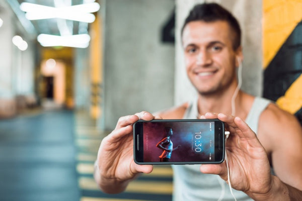 Free Man In Gym Holding Smartphone Mockup Psd