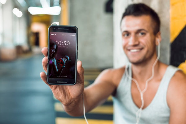 Free Man In Gym Holding Smartphone Mockup Psd