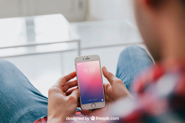 Free Man On Couch Looking At Smartphone Psd