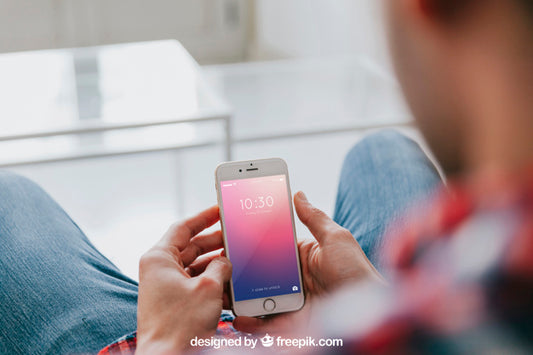 Free Man On Couch Looking At Smartphone Psd