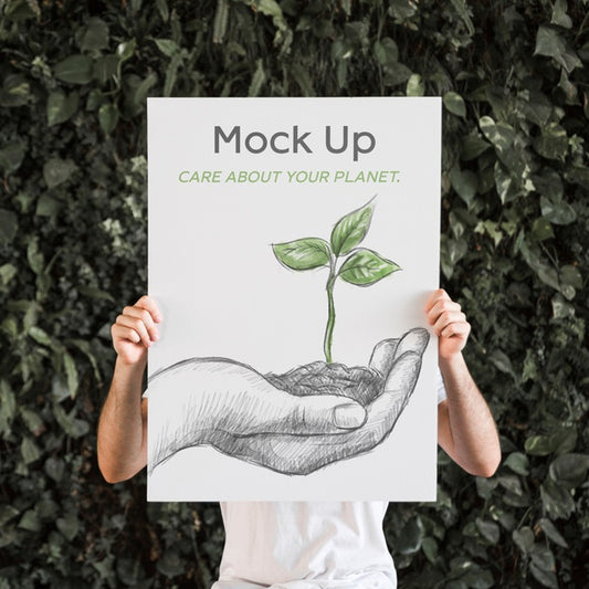 Free Man Presenting Poster Mockup In Front Of Leaves Psd