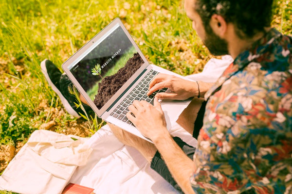 Free Man Using Laptop Mockup In Nature Psd