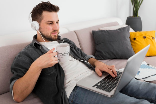 Free Man With Laptop Drinking From Mug Mock-Up Psd