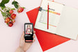 Free Mobile Beside Agenda And Flowers On Desk Psd