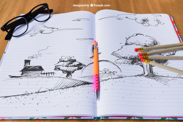 Free Notebook With Drawing Of Landscape, Pencils And Glasses Psd