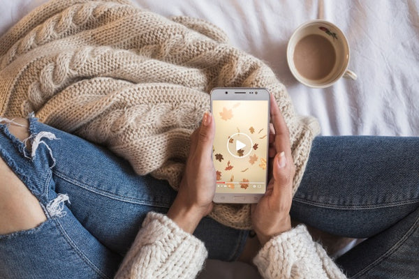 Free Person On Bed Looking At Smartphone With Autumn Concept Psd