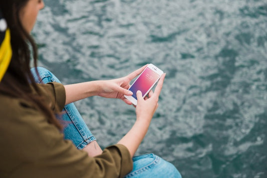 Free Person Using Smartphone Mockup On Sea Background Psd