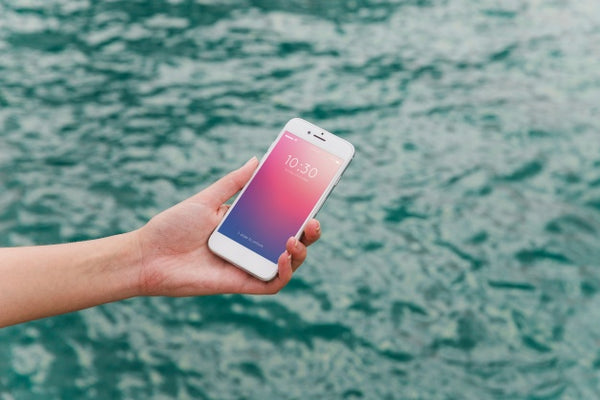 Free Person Using Smartphone Mockup On Sea Background Psd