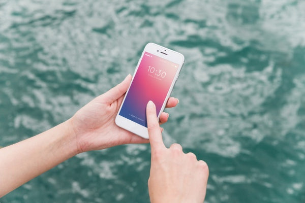 Free Person Using Smartphone Mockup On Sea Background Psd