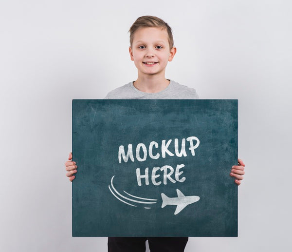 Free Portrait Of Young Boy Holding Mock-Up Sign Psd