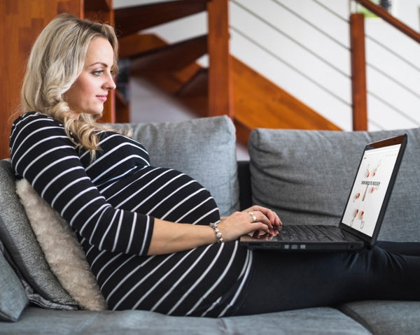 Free Pregnant Woman On Couch Using Computer Psd