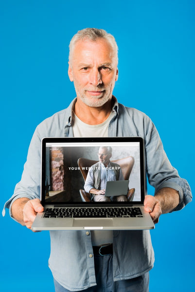 Free Senior Man Presenting Laptop Mockup Psd