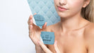 Free Smiley Woman Holding A Skincare Product Mock-Up Psd