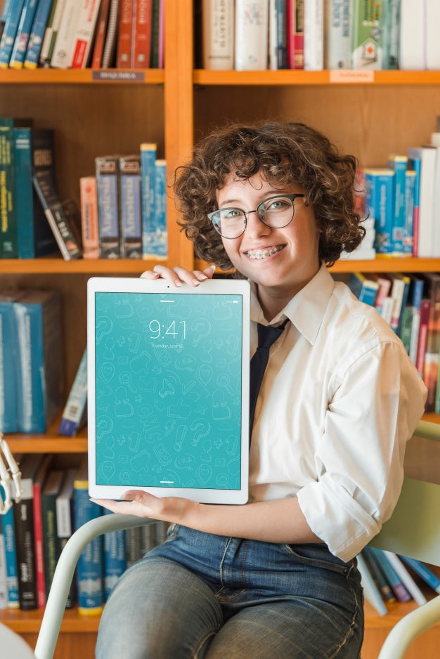 Free Smiling Woman Holding Tablet Mockup In Library Psd