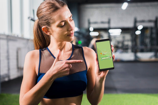 Free Sporty Woman Pointing At Smartphone Mockup Psd