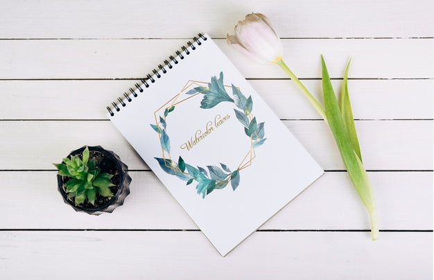 Free Spring Notebook Mockup With Decorative Plant In Top View Psd