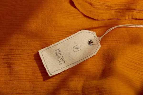 Free Top View Of Clothing Label On Orange Textile Psd