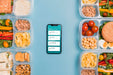 Free Top View Of Planned Meals With Smartphone Psd