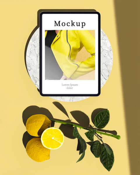 Free Top View Of Tablet With Citrus And Leaves Psd