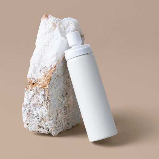 Free White Spray Bottle Mockup Against A Rock Psd