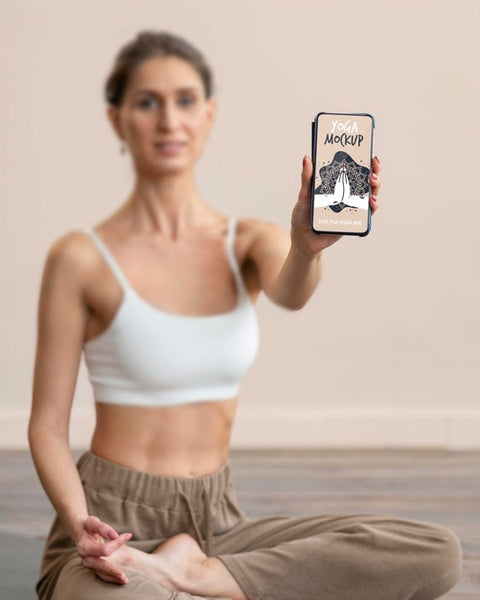 Free Woman Doing Yoga And Holding Smartphone Psd