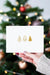 Free Woman Holding A Christmas Card In Front Of A Christmas Tree Mockup Psd