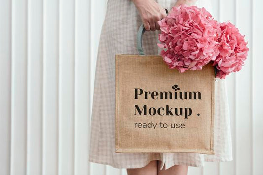 Free Woman Holding A Woven Tote Bag Mockup With Pink Hydrangea Flowers Psd