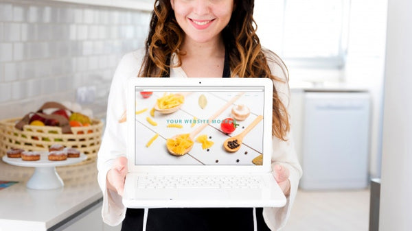 Free Woman In Kitchen Presenting Laptop Mockup Psd