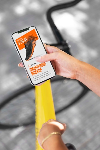 Free Woman Using Mock-Up Smartphone Outdoors While On Bicycle Psd